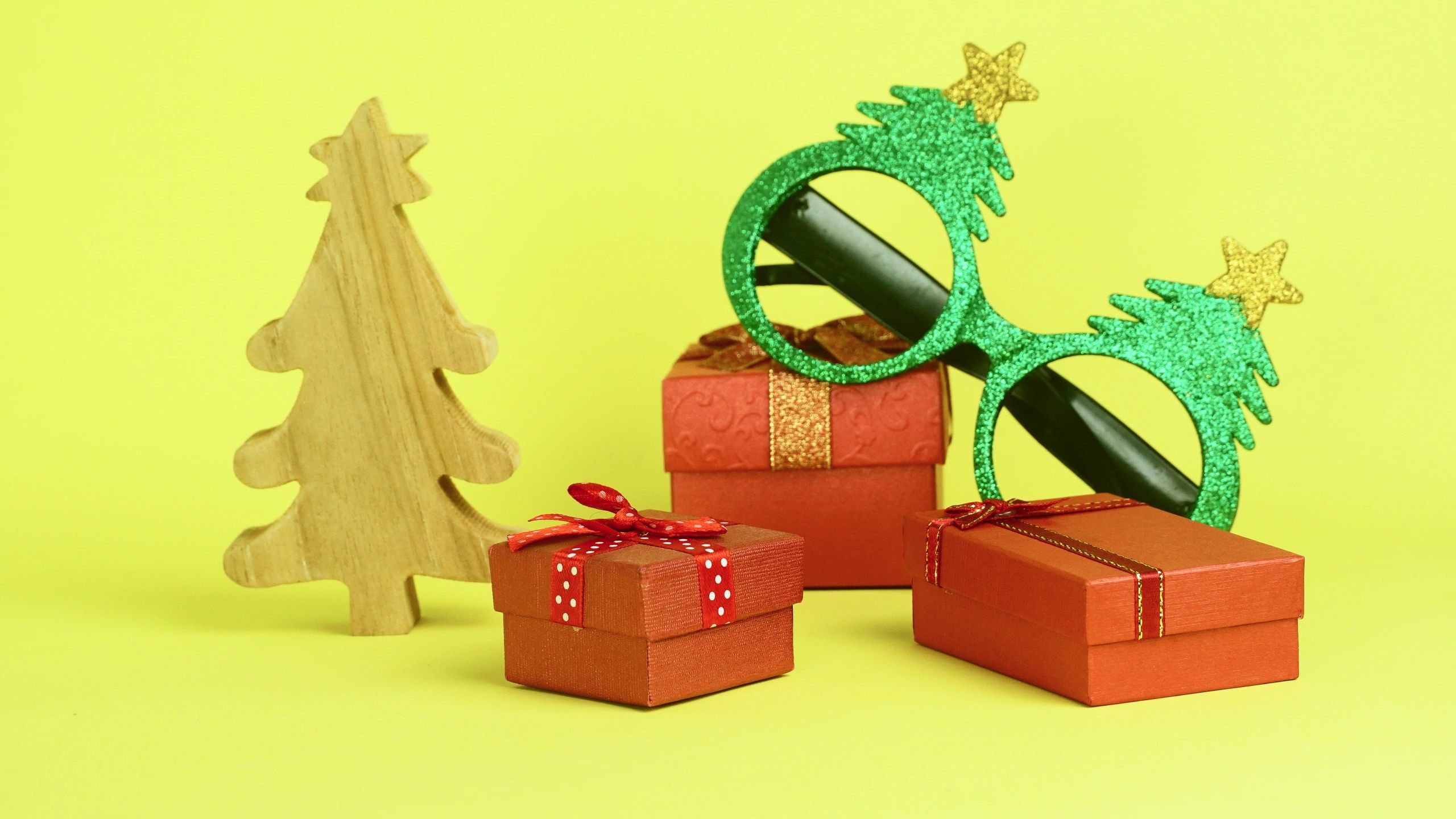Red gift boxes and small wooden Christmas tree in a festive arrangement