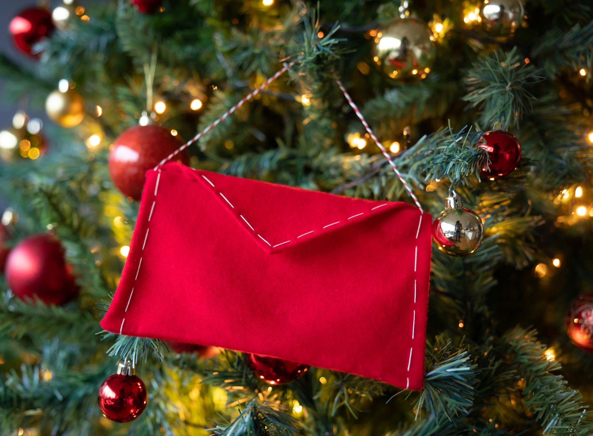 Letter for Santa placed near a Christmas tree