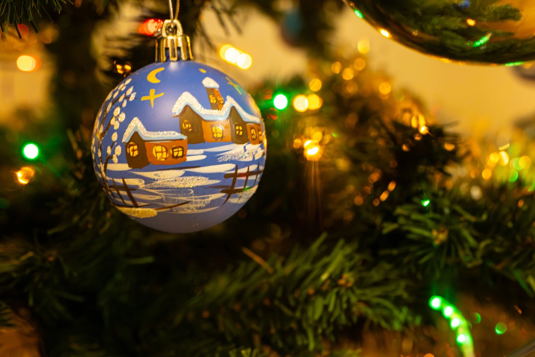 Painted Christmas ornament hanging on a tree