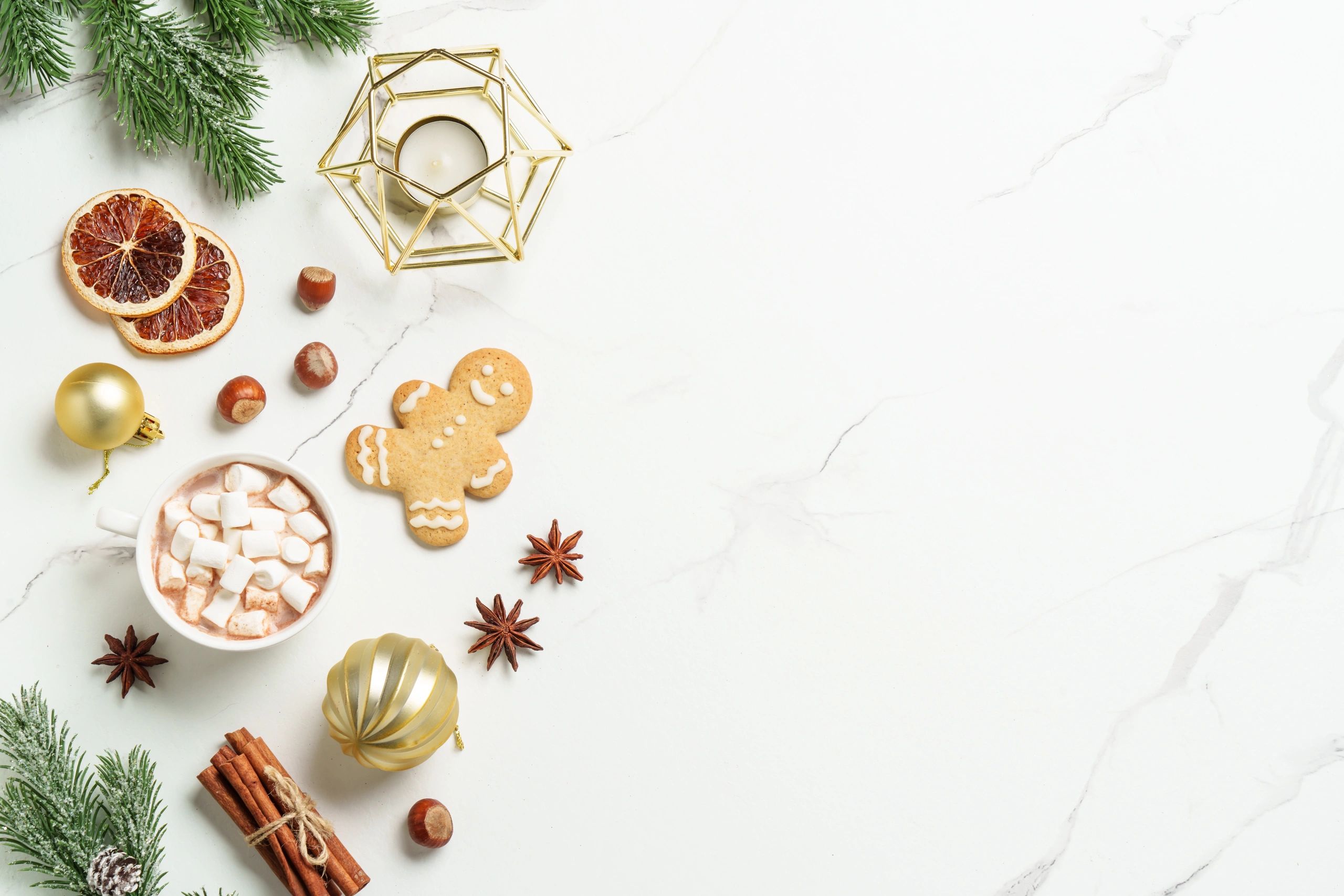 Christmas spices with gingerbread cookies and hot chocolate on a marble background